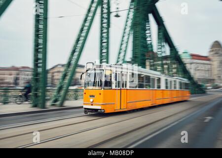 Alte gelbe Tram in Bewegung auf der Iron Bridge. Stadt leben in Budapest, Ungarn. Stockfoto