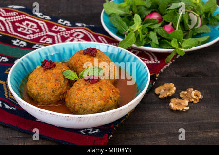 Koofteh Tabrizi große Frikadellen gefüllt mit getrockneten Früchten und Nüssen in Tomaten Kurkuma Brühe eine traditionelle aserbaidschanische und iranischen Gericht serviert in Türkis B Stockfoto