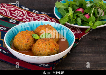 Koofteh Tabrizi große Frikadellen gefüllt mit getrockneten Früchten, Beeren und Nüsse in Tomaten Kurkuma Brühe eine traditionelle aserbaidschanische und iranischen Gericht serviert In Tu Stockfoto