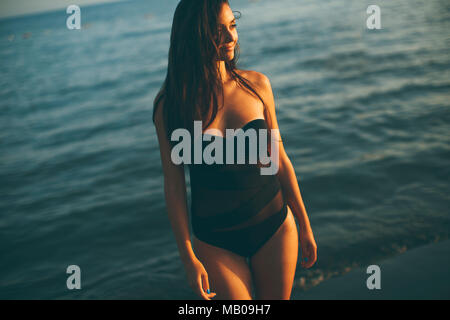 Hübsche, junge Frau im Meer auf einem sunnset des Sommertages Stockfoto