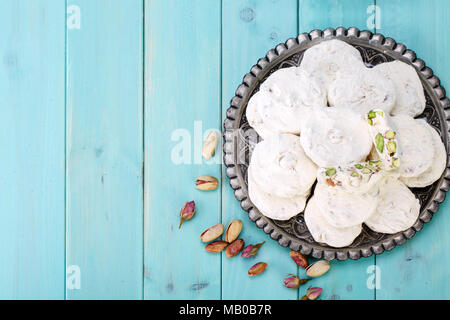 Von oben traditionelle iranische und persischen Stücke der weißen Nougat Dessert süsse bonbons (GAZ) mit Pistazien aus Isfahan Stadt auf Blau turquoi Schuß Stockfoto