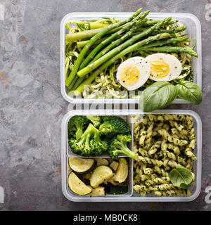 Vegetarische Mahlzeit prep Container mit Eiern, Zucchini Nudeln und Pasta mit grünem Pesto und Gemüse Stockfoto