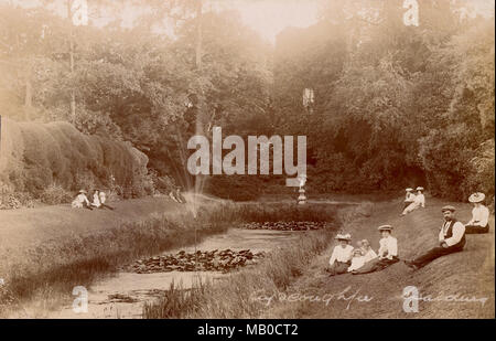 Ayscoughfee Gärten, Spalding, Lincolnshire. Ein gescanntes und restauriert Postkarte des Edwardianischen Leute sitzen am See und Owl Turm im Jahre 1905. Sepia Bild aus einem Foto von beales der Spalding. Stockfoto