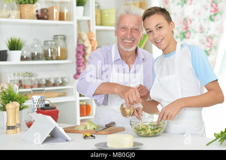 Älterer Mann mit Enkel Vorbereitung Abendessen in der Küche Stockfoto
