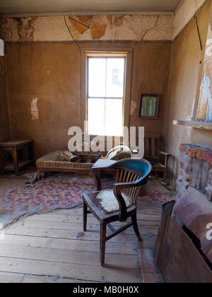 Werfen Sie einen Blick in das Wohnzimmer eines verlassenen, öden Gebäude an Bodie State Historic Park, einem ehemaligen Wilden Westen Goldrausch Boomtown, jetzt eine Geisterstadt. Stockfoto