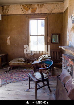 Werfen Sie einen Blick in das Wohnzimmer eines verlassenen, öden Gebäude an Bodie State Historic Park, einem ehemaligen Wilden Westen Goldrausch Boomtown, jetzt eine Geisterstadt. Stockfoto