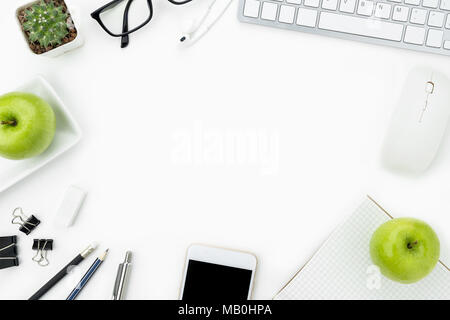 Weiß Schreibtisch Tisch mit einer Menge von Bürobedarf über es mit Äpfeln. Gesunde Arbeitsbedingungen Konzept. Ansicht von oben mit der Kopie Raum, flach. Stockfoto