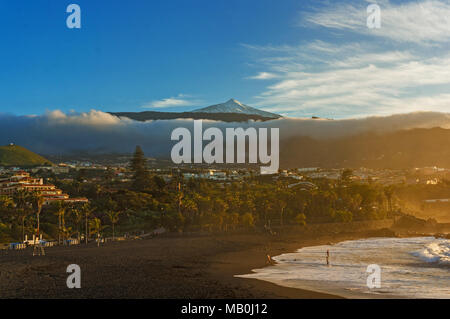 Sunset Beach anzeigen. Goldenes Licht, schwarzem Sand. Lange Cloud unter Mountain Top. Blauer Himmel, Palmen. Paradies Landschaft. Urlaub reisen. Playa Jardin i Stockfoto