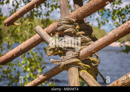 Traditionell gewebte wattle Zaun im ländlichen Schweden, an einem See. Stockfoto