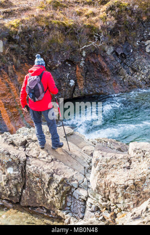 Man steht auf Felsen an Fairy Pools, Fluss Spröde, Isle of Skye, Schottland, UK im März Stockfoto