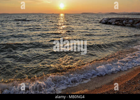 Kleine Wellen an der Küste während der Goldenen Stunde entlang der Küste kommen. Eine kühne und dramatische Szene von Blau, frisches Wasser. Horizontale, kopieren. Stockfoto