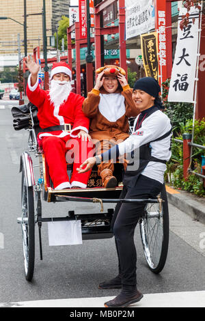 Japan, Hoshu, Tokyo, Asakusa, Paar verkleidet als Weihnachtsmann und Rentiere in der Rikscha Stockfoto