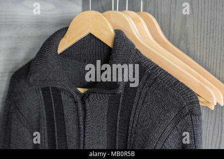 Ein Aufhänger mit Sachen. Gestrickte Pullover hängen auf Kleiderbügeln. Hellen Pullover. Frühling Kleidung. Stockfoto