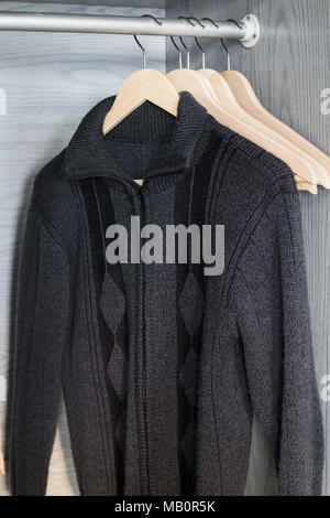 Ein Aufhänger mit Sachen. Gestrickte Pullover hängen auf Kleiderbügeln. Hellen Pullover. Frühling Kleidung. Stockfoto