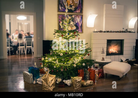 Weihnachtsbaum und Familie beim Abendessen Stockfoto