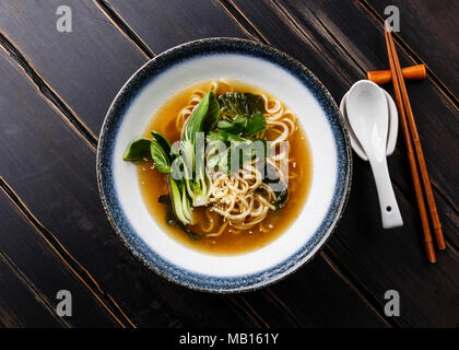 Ramen asiatische Nudel in Brühe mit Pak Choi Kohl in Schüssel auf dunklem Hintergrund Stockfoto