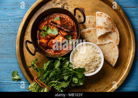Chicken Tikka Masala scharf Curry Fleisch essen mit Reis und Naan Brot auf Kupfer Tablett close-up Stockfoto