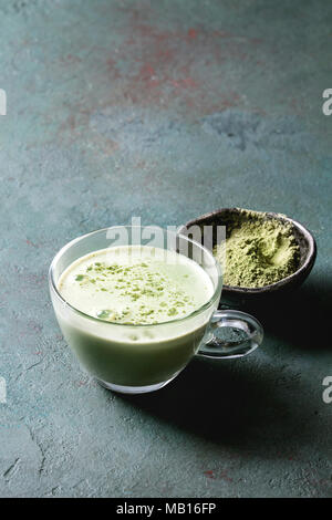 Tasse Matcha Latte mit Schale Matcha Tee über Grau Grün Textur Hintergrund. Kopieren Sie Platz. Stockfoto