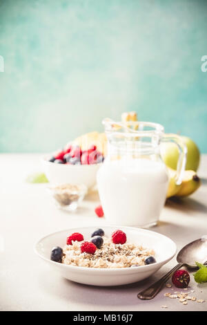 Haferflocken Haferbrei mit frischen Beeren, Früchte und Mandelmilch. Gesundes Frühstück, gesunde Ernährung, veganes Essen Konzept. Stockfoto