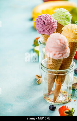 Verschiedene Eissorten Aroma in der Kegel rosa (Erdbeere, Himbeere), Violett (Blueberry), Grün (Pistazie, grüner Tee, Kalk) und gelb (Mango, Banane) s Stockfoto