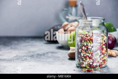 Hülsenfrüchte - Linsen Kichererbsen Bohnen Erbsen im Glas und rohem Gemüse. Vegan protein Quelle. Vegetarische und gesunde Ernährung Konzept Stockfoto