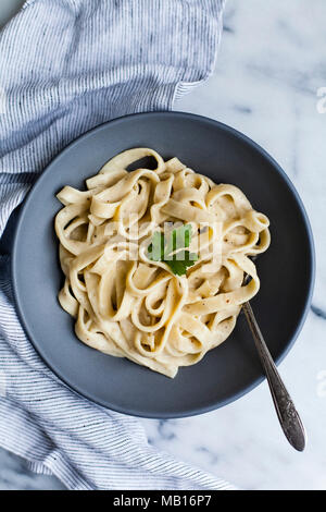 Cremige Pasta in blaue Schale auf Marmor Stockfoto