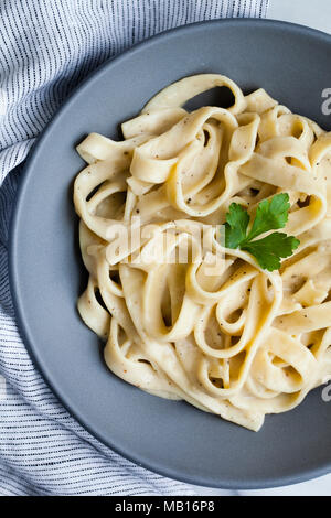 Cremige Pasta in blaue Schale auf Marmor Stockfoto