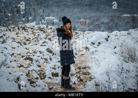 Recht jugendlich Mädchen im Schnee, Frontkamera, winter Thema. Schönen kaukasischen Jugendmädchen in Schnee, schneebedeckten Berge im Hintergrund. Stockfoto