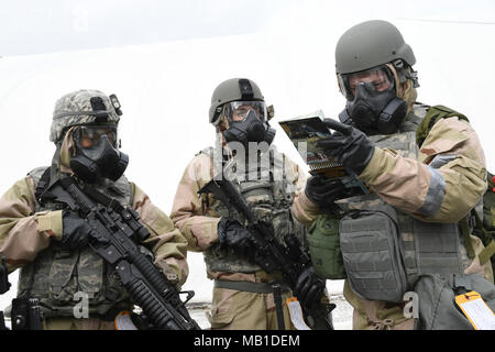 Senior Airman Ajay einzustellen und Airman 1st Class Alexandre Couture, beide Mitglieder der 66th Sicherheitskräfte Squadron, sowie Staff Sgt. David Clark, ein Mitglied der Judge Advocate Office, schauen Sie über ein Blindgänger Field Guide während einer Übung an hanscom Air Force Base, Mass., Nov. 2. Die Ausbildung, auch bekannt als die Fähigkeit, zu überleben und zu bedienen, oder ATSO, bereitet die Flieger in einer bereitgestellten Umgebung zu operieren. Stockfoto