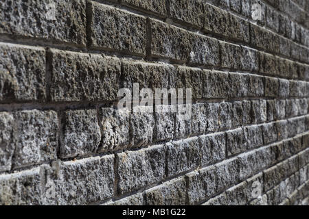 Vordere Nahaufnahme eines Ziegelstein vintage Wand in einem Winkel von 45 Grad. Ziegel sind Grau und Weiß. Stockfoto