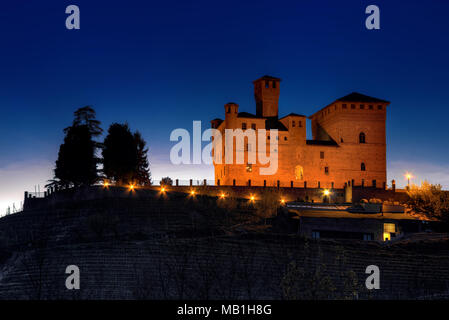 Das Schloss von Grinzane Cavour (UNESCO-Weltkulturerbe), Sitz der Alba Weiße Trüffel Welt Auktion, bei Einbruch der Dunkelheit beleuchtet. Stockfoto
