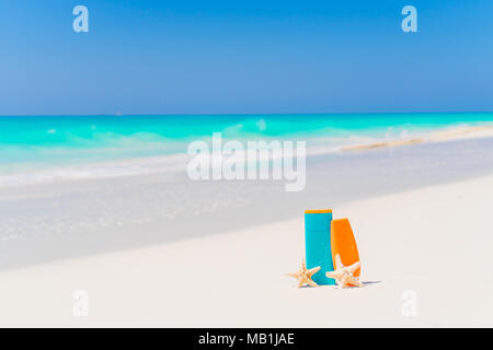 Sonnencreme Flaschen, Gläser, Seesterne am White Sand Beach Stockfoto