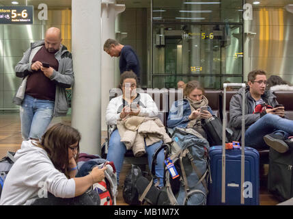 Menschen im Wartezimmer Eurostar Bahnhof St Pancras, London, England, alle Mobiltelefone zu benutzen Stockfoto