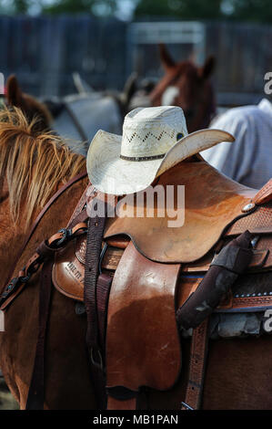 Cowboyhut, Sattel und Pferd auf dem Rodeo-Gelände der Tsuut'ina Nation in Bragg Creek, Alberta Stockfoto