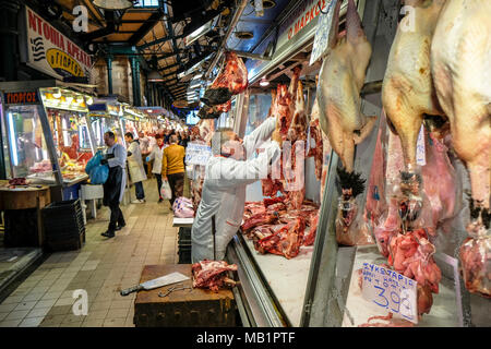 Athen, Griechenland - Dezember 29, 2017: ein Metzger Fleisch vorbereiten für einen Kunden in zentralen Markt in Athen, Griechenland. Stockfoto