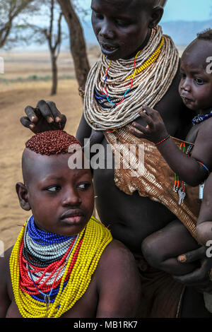 Omo Valley, Äthiopien - Januar 26, 2018: Nicht identifizierte Frau des Karo Stammes mit traditionellen Schmuck und ihrem Sohn in Omo Valley, Äthiopien. Stockfoto