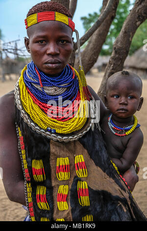 Omo Valley, Äthiopien - Januar 26, 2018: Nicht identifizierte Frau des Karo Stammes mit traditionellen Schmuck und ihrem Sohn in Omo Valley, Äthiopien. Stockfoto