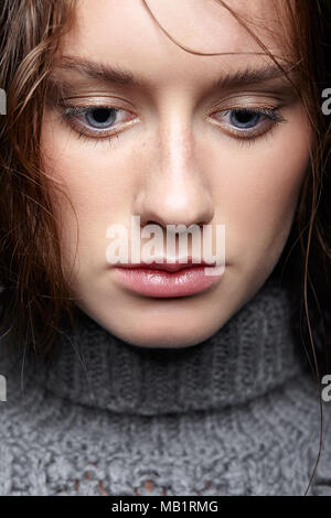 Schönheit Porträt der jungen Frau in grauer Wolle Pullover. Brünette Mädchen mit hellen blauen Augen und Tag weibliche Make-up. Stockfoto