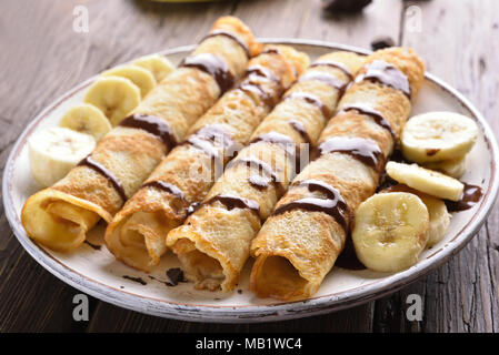 Crepes mit bananenscheiben auf hölzernen Tisch. Nähe zu sehen. Stockfoto