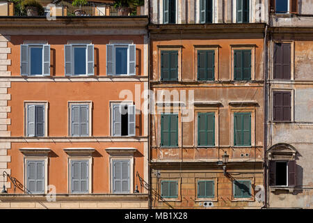 Fenster und Rollläden auf die verwitterte Fassade der Gebäude in Rom, Italien, an einem sonnigen Tag im August. Stockfoto