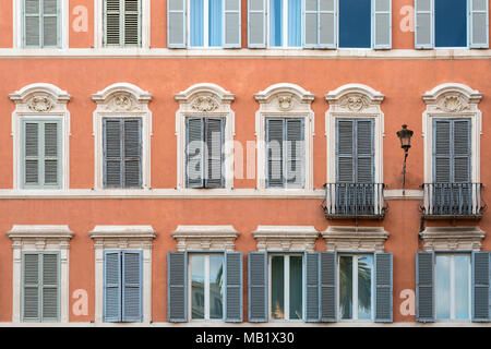 Fenster und Rollläden auf einem terrakottafarbenen Gebäude in Piazza di Spagna, Rom, Italien. Stockfoto