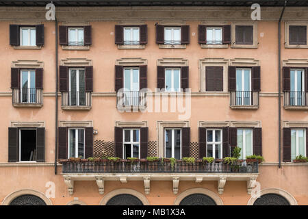 Fenster, Fensterläden und einem Balkon auf einem Gebäude mit Blick auf Piazza Navona in Rom, Italien. Einige der Fenster zeigen Reflexionen der Gebäude opposi Stockfoto
