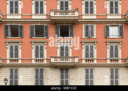 Fenster und Rollläden auf ein Gebäude mit terrakottafarbenen Wänden in der Nähe von Petersplatz in Rom, Italien. Stockfoto