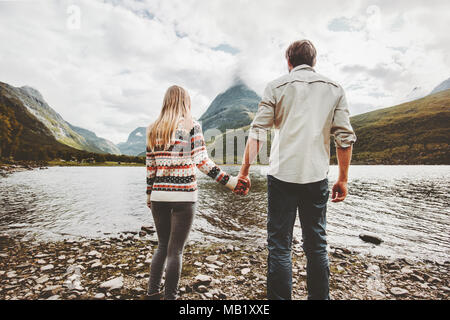 Paar Mann und Frau halten sich an den Händen Berge und Seeblick zusammen reisen Abenteuer lifestyle Konzept Ferien im Freien genießen.