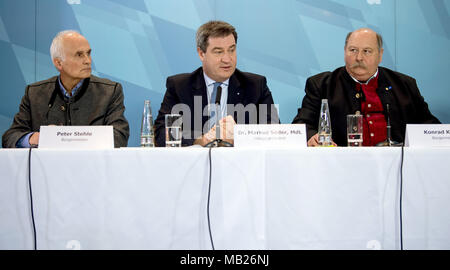 06 April 2018, Deutschland, München: Peter Stehle (L-R), Bürgermeister von Bad Kohlgrub, Bayerischer Ministerpräsident Markus Soeder (CSU) und Konrad Kienle (CSU), Bürgermeister von Balderschwang, geben eine Pressekonferenz in der Bayerischen Staatskanzlei. Ein neues Bauprojekt der einen zentralen Access Point (chischaukel") zwischen verschiedenen Skipisten am Riedberger Horn wird derzeit diskutiert. Foto: Sven Hoppe/dpa Stockfoto