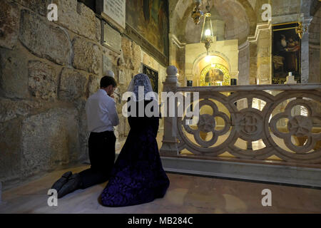 Christlich-orthodoxe Gläubige knien während des Karfreitags der orthodoxen heiligen Woche im Gebet in der Kapelle St. Helena in der Grabeskirche, die Helena, der Mutter des Kaisers Konstantin, gewidmet ist, die nach Überlieferung das Kreuz bei ihrem Besuch 326 n. Chr. in der Altstadt von Jerusalem, Israel, entdeckte. Orthodoxe Christen auf der ganzen Welt gedenken der Ereignisse um die Kreuzigung Jesu Christi, die zu seiner Auferstehung am Ostern führten. Stockfoto