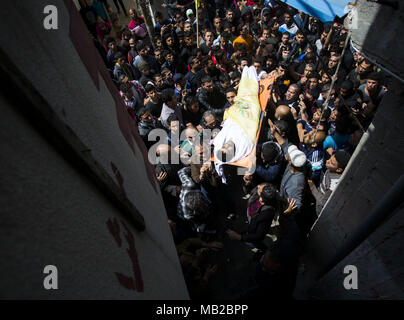 Gaza, Gaza, Palästina. 6 Apr, 2018. Palästinenser trauernde tragen die Körper der 30-jährige Thaer Rabaa während seiner Beerdigung im Flüchtlingslager Jabalia im nördlichen Gazastreifen. Rabaa tot war durch die israelischen Streitkräfte im Gaza-Streifen Grenze erschossen, das Gesundheitsministerium im Streifen sagte, als die Spannungen blieben die Tage nach dem 17 Menschen getötet wurden, als eine Massendemonstration zu Auseinandersetzungen geführt. Credit: Mahmoud Issa/Quds Net News/ZUMA Draht/Alamy leben Nachrichten Stockfoto