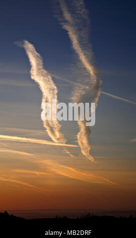 Kondensstreifen am Himmel über North Wales in der Morgendämmerung Stockfoto