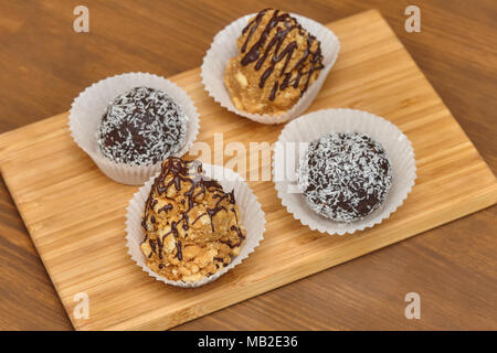 Bonbons mit Kokosnuss und Schokolade Topping auf Holz- Hintergrund Stockfoto