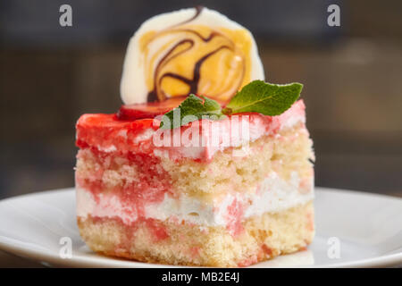 Erdbeerkuchen mit rosa Marmelade auf weißen Teller bedeckt, Nahaufnahme Stockfoto